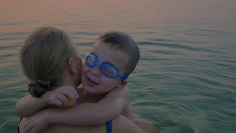 Hugs-and-kisses-of-mother-with-son-in-the-sea