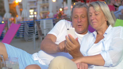 Älteres-Paar-Mit-Smartphone-Am-Strand
