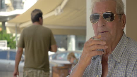 Älterer-Mann-Mit-Sonnenbrille,-Der-Auf-Der-Straße-Raucht