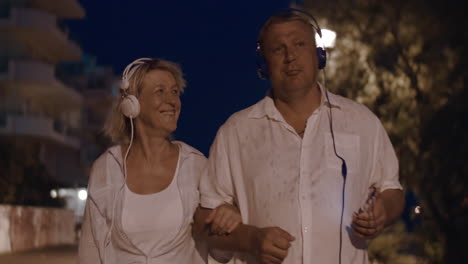 Senior-couple-listening-to-music-during-night-walk