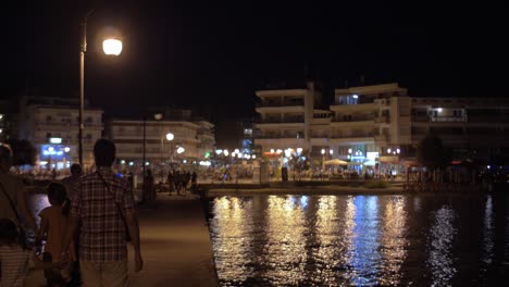 People-walking-on-pier-at-night