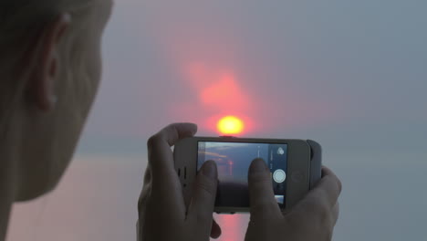 Woman-taking-sunset-pictures-with-iPhone