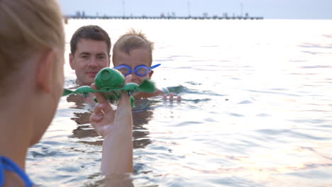 Familie-Spielt-Mit-Schwimmspielzeug-Im-Meer