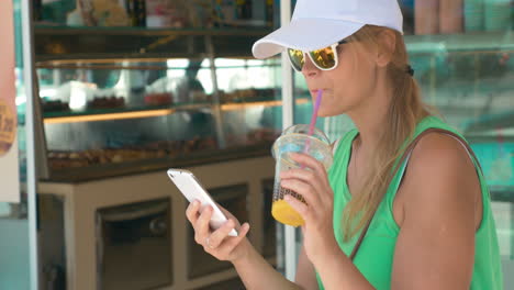 Woman-using-phone-in-street-on-summer-day