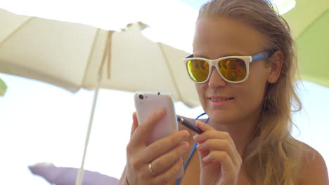 Close-up-of-blonde-woman-using-smartphone