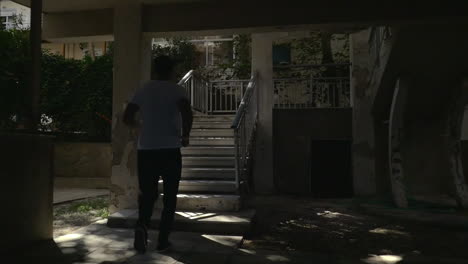 Man-running-up-the-steps-of-outdoor-stairways-in-hotel