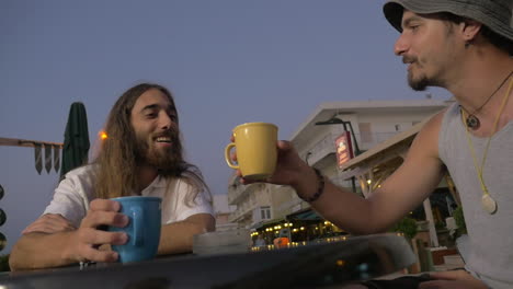 Viejos-Amigos-Tocando-Tazas-En-Un-Café-Al-Aire-Libre