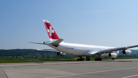 Swiss-Airbus-A340-überprüft-Das-Heckruder-Beim-Rollen-Zur-Landebahn-An-Einem-Sonnigen-Tag