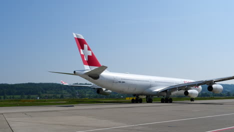 Airbus-A340-Suizo-Comprobando-El-Timón-De-Cola-Mientras-Rueda-Hacia-La-Pista-En-Un-Día-Soleado