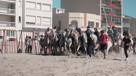 Jinetes-A-Caballo-Desfilan-Antes-De-Correr-Los-Toros-En-La-Playa-De-Palavas-Les-Flots-Como-Parte-De-La-Feria-De-Otoño-De-La-Ciudad,-Herault,-Francia