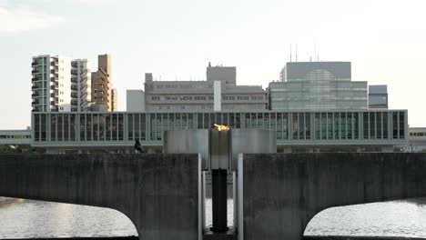 Llama-De-La-Paz-En-El-Parque-Conmemorativo-De-La-Paz-De-Hiroshima-Con-El-Museo-Conmemorativo-De-La-Paz-Al-Fondo