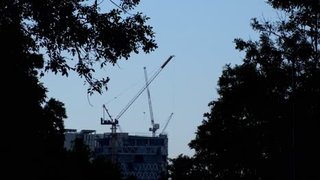Camera-zooms-out-revealing-this-silhouette-scenario-of-Cranes-and-Construction,-Bangkok,-Thailand