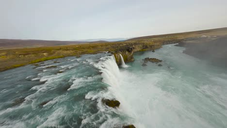 Toma-De-Establecimiento-Fpv-De-Turistas-Observando-La-Cascada-De-Godafoss-En-Islandia