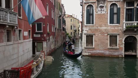 Los-Turistas-Disfrutan-De-Un-Paseo-En-Góndola-Tradicional-En-El-Canal-De-Venecia,-Italia.