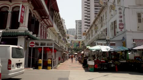 Busy-Chinatown-street-in-Singapore-with-traffic-and-people-walking