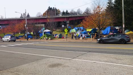 A-long-shot-of-homeless-people-near-tents-set-up-under-a-bridge-in-Portland-Maine