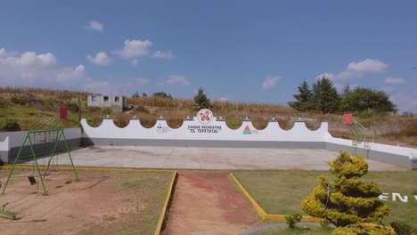 Behold-this-astounding-capture-of-Amoloya-town's-petite-park,-adorned-with-parched-brown-bushes-and-a-sprinkle-of-trees-shimmering-in-the-backdrop,-in-Ecatepec-de-Morelos,-Mexico