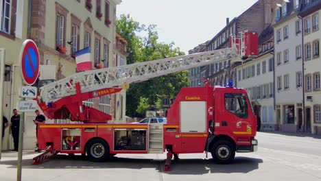 French-firetruck-stationed-in-a-village-moving-the-aerial-ladder-with-a-French-flag-in-background