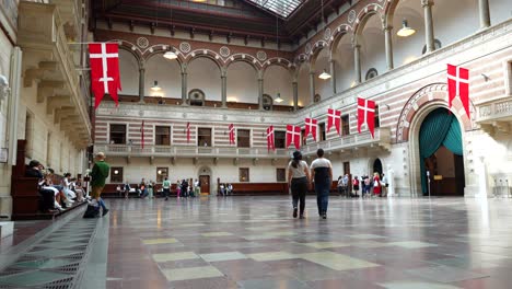 Interior-Del-Ayuntamiento-De-Copenhague-Con-Una-Pareja-De-Turistas-Caminando-Y-Besándose