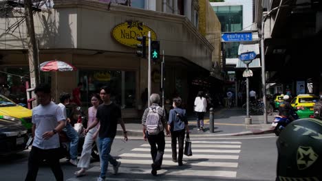 People-crossing-the-Pedestrian-Lane-in-Sukhumvit-24-in-front-of-the-Naraya-shop,-Bangkok,-Thailand