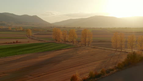 Helle-Sonne-Scheint-Im-Herbst-Bei-Sonnenaufgang-über-Den-Landwirtschaftlichen-Feldern-Und-Den-Bergen