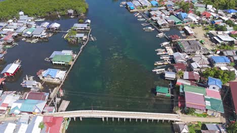 Atemberaubende-Luftdrohnenaufnahmen-Des-Schwimmenden-Dorfes-Day-Asan-In-Surigao-Del-Norte-Mit-Wunderschönem-Klarem-Wasser-Und-Farbenfrohen-Metalldächern
