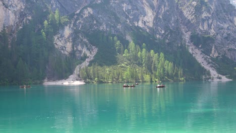 Static-shot-of-typical-wooden-row-boats-with-tourists-in-Lago-di-Braies,-Italy
