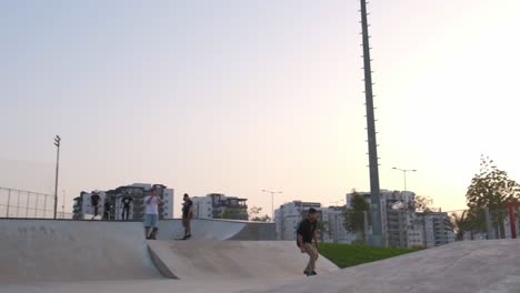 Slow-motion-of-a-young-man-performing-skateboard-tricks-at-sunset-in-a-tourist-spot,-Skater-guy-doing-a-kickflip,-Sporty-skateboarder-practicing-at-skatepark,-Extreme-sports