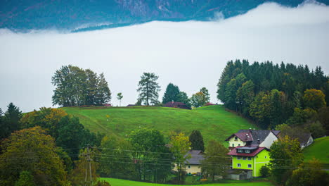 Austrian-village-with-low-lying-fog-in-the-valley-beneath-the-alps---time-lapse