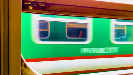 View-Of-A-Passing-Train-Through-Another-Train-Window-In-Bangladesh