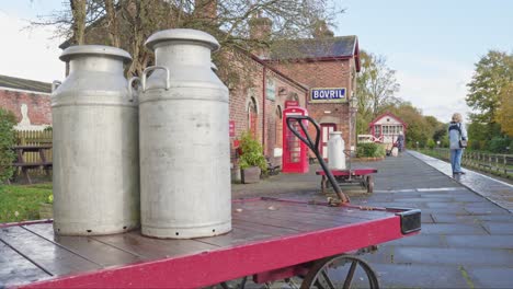 Retro-Steel-milk-churns-on-hand-cart-nostalgic-railway-platform-scene