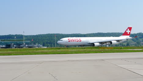 Toma-De-Seguimiento-Del-Airbus-A340-300-Suizo-Despegando-En-El-Aeropuerto-De-Zurich-En-Un-Día-Soleado,-Slomo