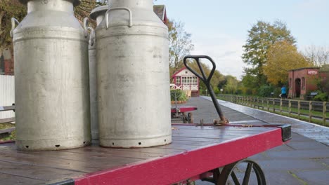 Vintage-milk-churns-on-hand-cart-nostalgic-railway-platform-scene