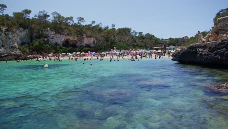 Mallorca:-Vista-Lateral-De-La-Playa-Del-Resort-En-Cala-Liombards-En-La-Isla-De-Mallorca,-España,-Europa-|-Gente-Mirando-Nadadores