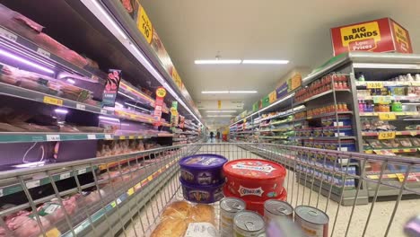 POV-supermarket-shopping-cart-walking-down-meat-grocery-products-aisle