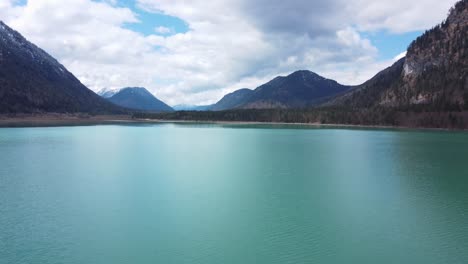 Turquoise-lake-nestled-between-snow-dusted-mountains