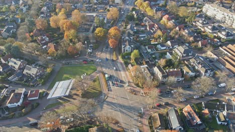 Aerial-of-a-busy-main-road-in-beautiful-rural-town-in-autumn---drone-flying-backwards