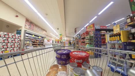 POV-Einkaufswagen-Im-Supermarkt,-Der-Den-Gang-Mit-Feinkostprodukten-Entlang-Läuft