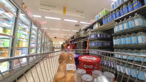 POV-supermarket-shopping-cart-walking-down-frozen-grocery-products-aisle