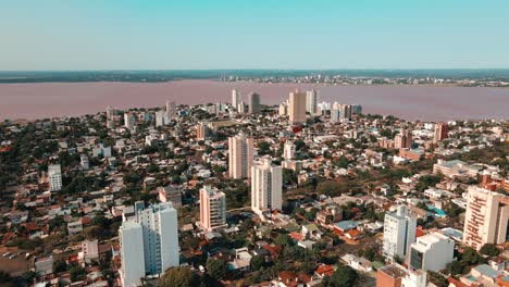 Drone-footage-reveals-Villa-Zarita-neighborhood-in-Posadas,-showcasing-the-stunning-Paraná-River,-separating-Argentina-from-Paraguay-in-the-background