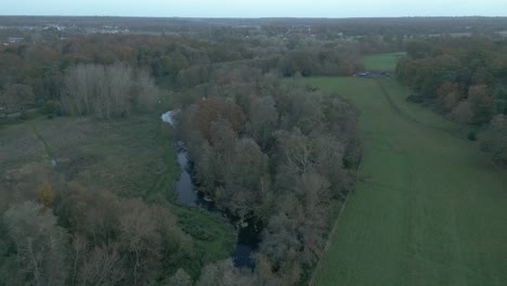 A-retreating-and-slightly-tilting-aerial-drone-shot-of-a-quite-village-in-the-outskirts-of-Thetford,-located-in-the-district-of-Breckland,-Norfolk-county,-east-of-London-in-United-Kingdom