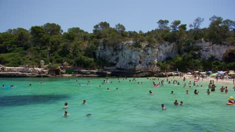 Mallorca:-Strandseitenansicht-Des-Resorts-In-Cala-Liombards-Auf-Der-Insel-Mallorca,-Spanien,-Europa-|-Nahaufnahme-Eines-überfüllten-Strandes