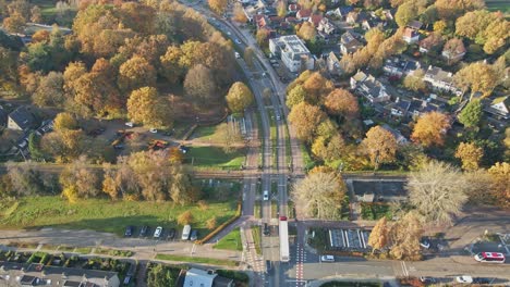 Aerial-of-truck-driving-over-train-overpass-in-a-small-town-on-a-sunny-autumn-day