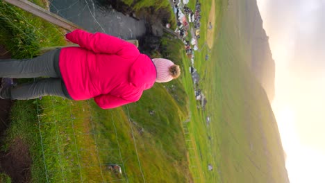 Happy-female-tourist-enjoys-sunset-from-Gjogv-viewpoint,-Faroe-Islands