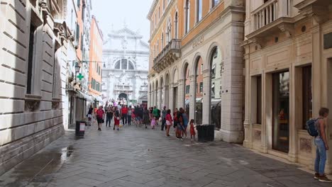 Pedestrian-traffic-on-street-with-luxury-fashion-stores-in-ancient-buildings-Venice,-Italy