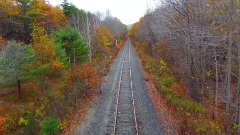 Aerial-view-of-Train-track-and-fall-colours-in-New-Hampshire,-USA
