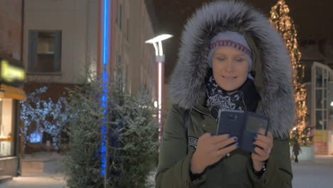 Frau-Macht-Handyfotos-Auf-Der-Straße-Mit-Weihnachtsbeleuchtung
