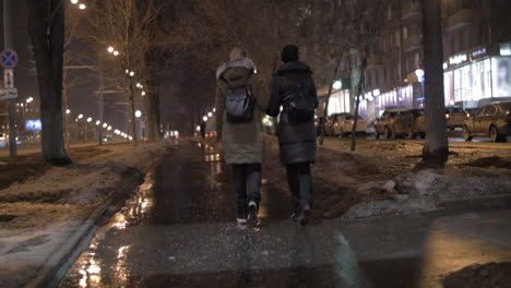 Friends-talking-during-evening-walk-in-winter-city