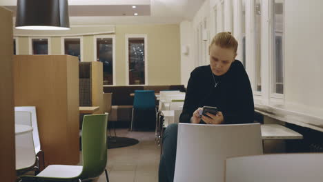 Woman-in-cafe-spending-lonely-evening-with-mobile