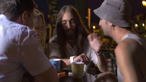 Friends-on-outdoor-cafe-discussing-smart-watch